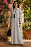 Striped monochrome maxi shirt dress in a garden setting, styled with black bag and rolled sleeves.