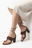 Woman wearing dark brown cruelty-free leather heel sandals with embroidered detailing by Saagah by Tjori