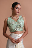 Mint green raw silk blouse with intricate mirror work embellishment for festive and wedding wear by Tjori