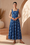 Woman wearing indigo geometric print cotton flared maxi dress with square neck and fitted bodice, front view