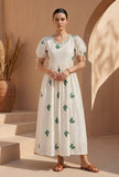Woman wearing ivory butterfly embroidered cotton midi dress with green embroidery and puff sleeves, front view