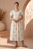 Woman wearing an ivory butterfly embroidered cotton gown dress by Tjori