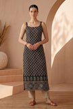 Woman wearing black ethnic motif printed strappy slip kurta with paisley and mandala border, styled with beige pants.
