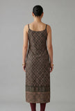 Back view of black ethnic motif printed cotton slip kurta with slim straps and patterned border at hem.
