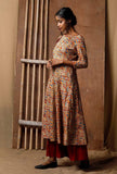 Side view of handcrafted Kalamkari cotton kurta in red, blue and mustard print, styled with red palazzo pants