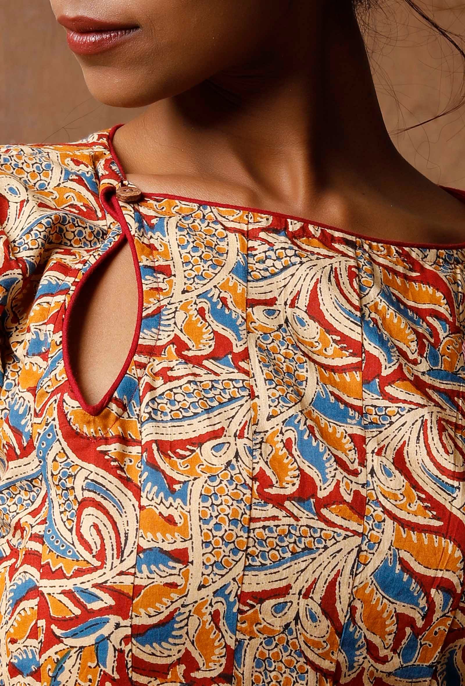Close-up of Kalamkari cotton kurta neckline with keyhole cutout and red, blue and mustard block print detail
